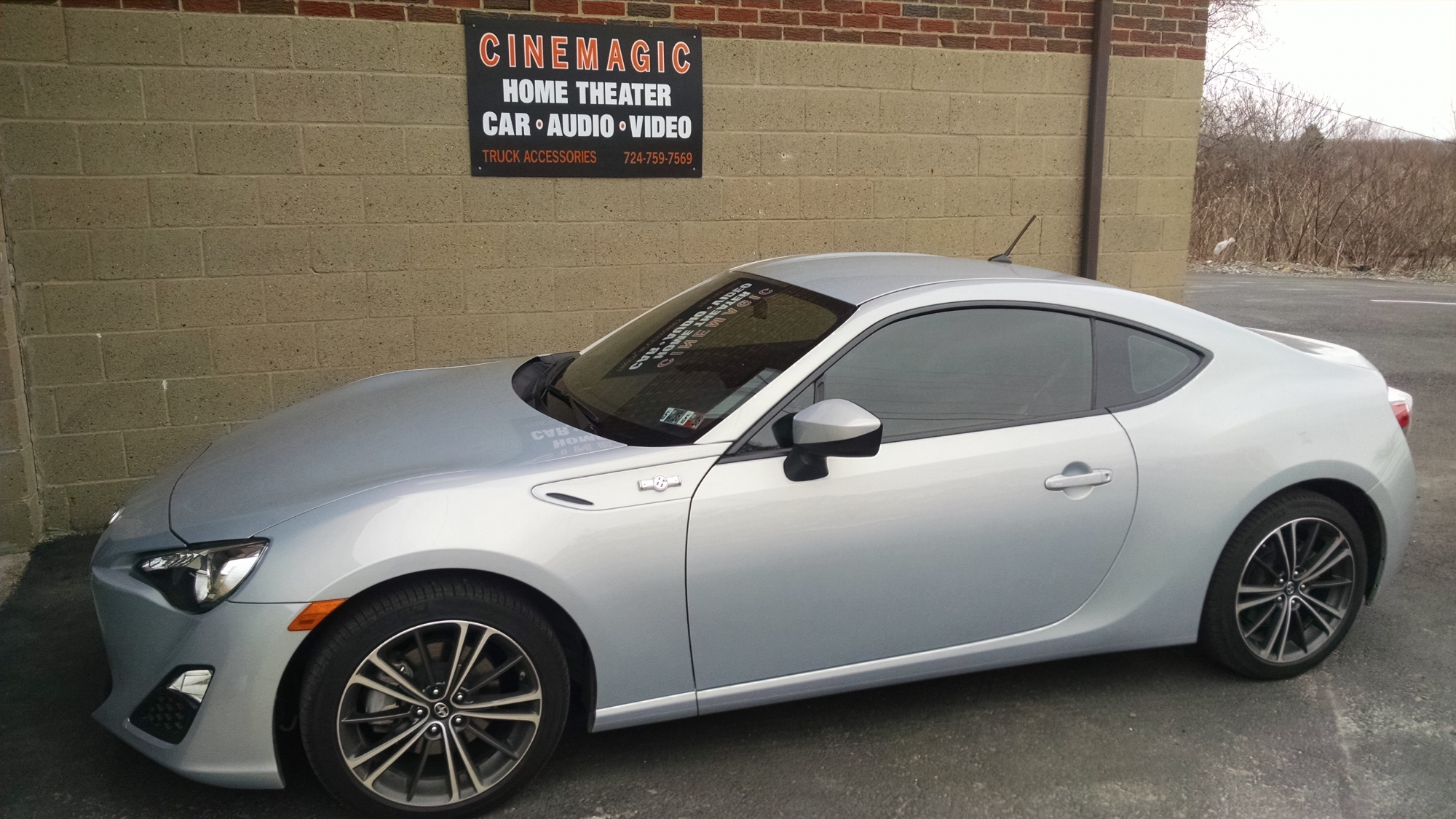 A silver car outside of Cinemagic Automotive Electronics' garage