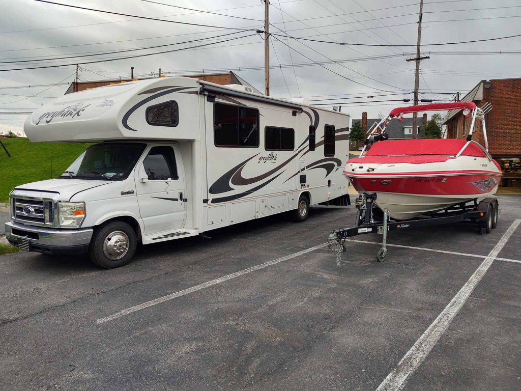 A red boat next to an RV